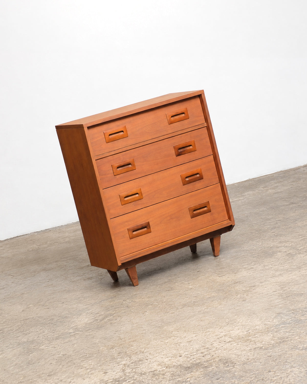 Angled view of the dresser front showing all four drawers and the tapered leg profile.
