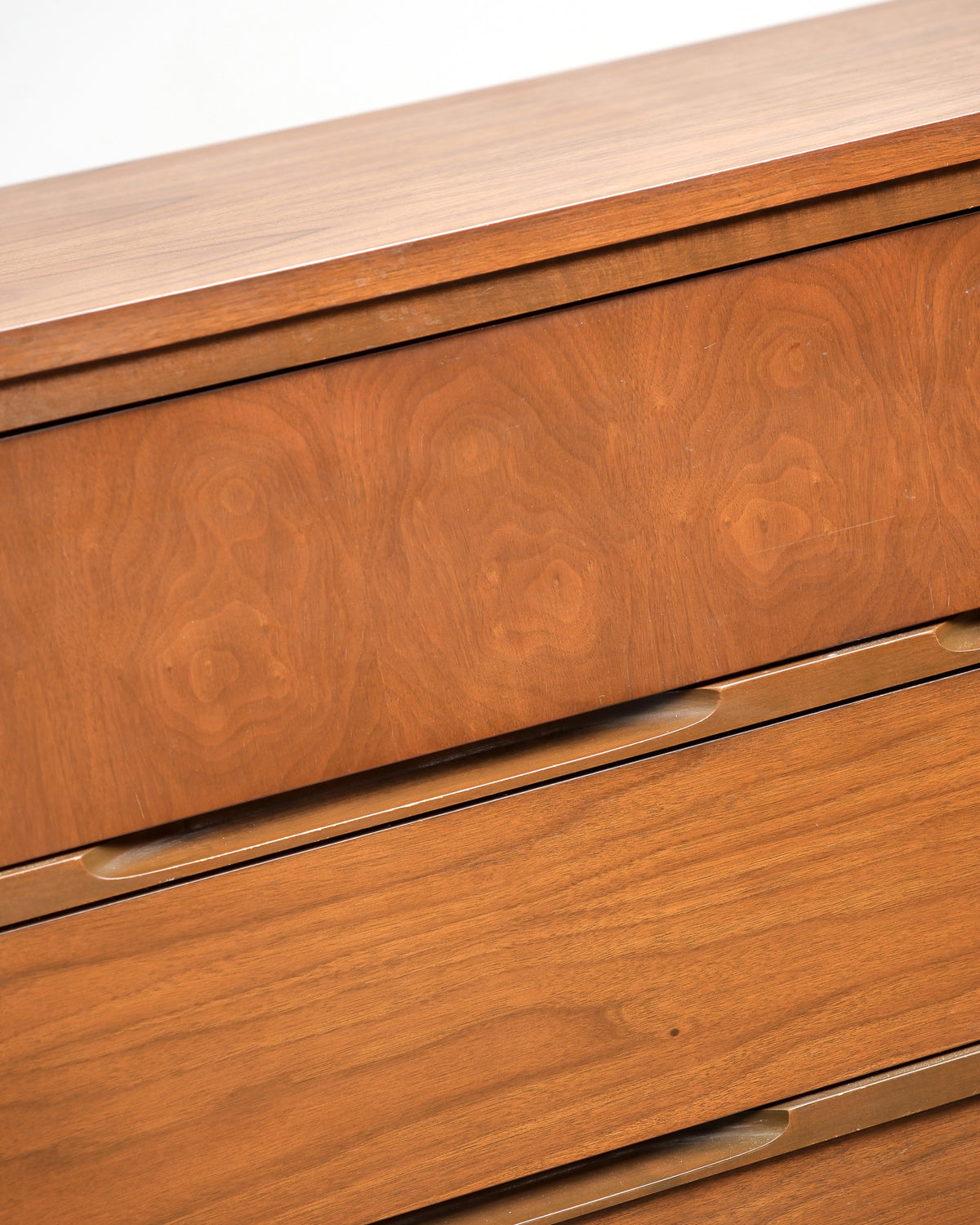 Detail of the recessed drawer pulls and walnut grain pattern.