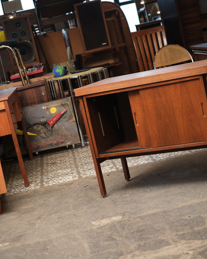 Angled view of the cabinet with one sliding door open, revealing the interior shelf