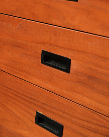 Close-up of the recessed black drawer pulls and natural teak grain.