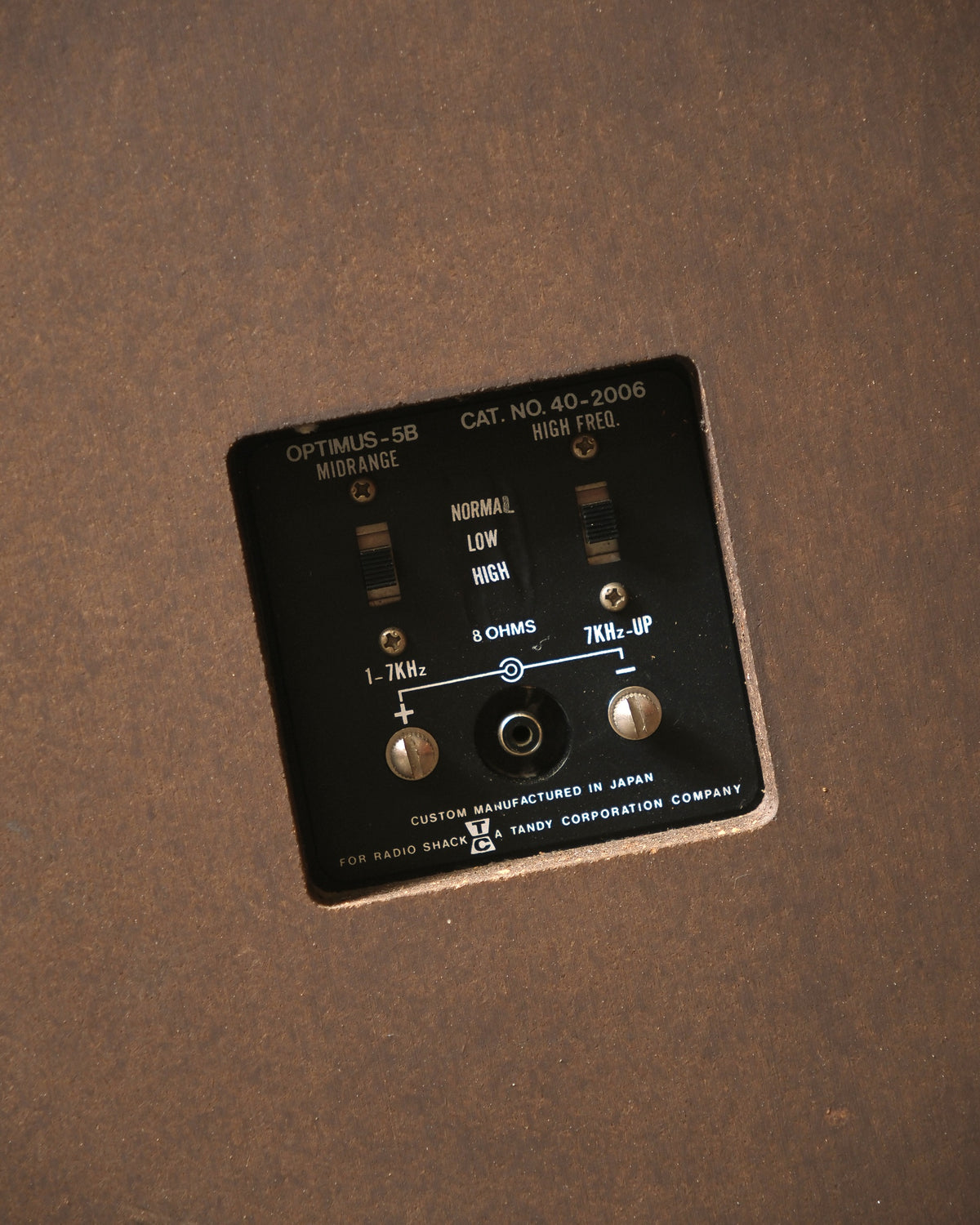 Close-up of the rear input panel on a vintage Realistic Optimus-5B speaker showing midrange and high freq controls.