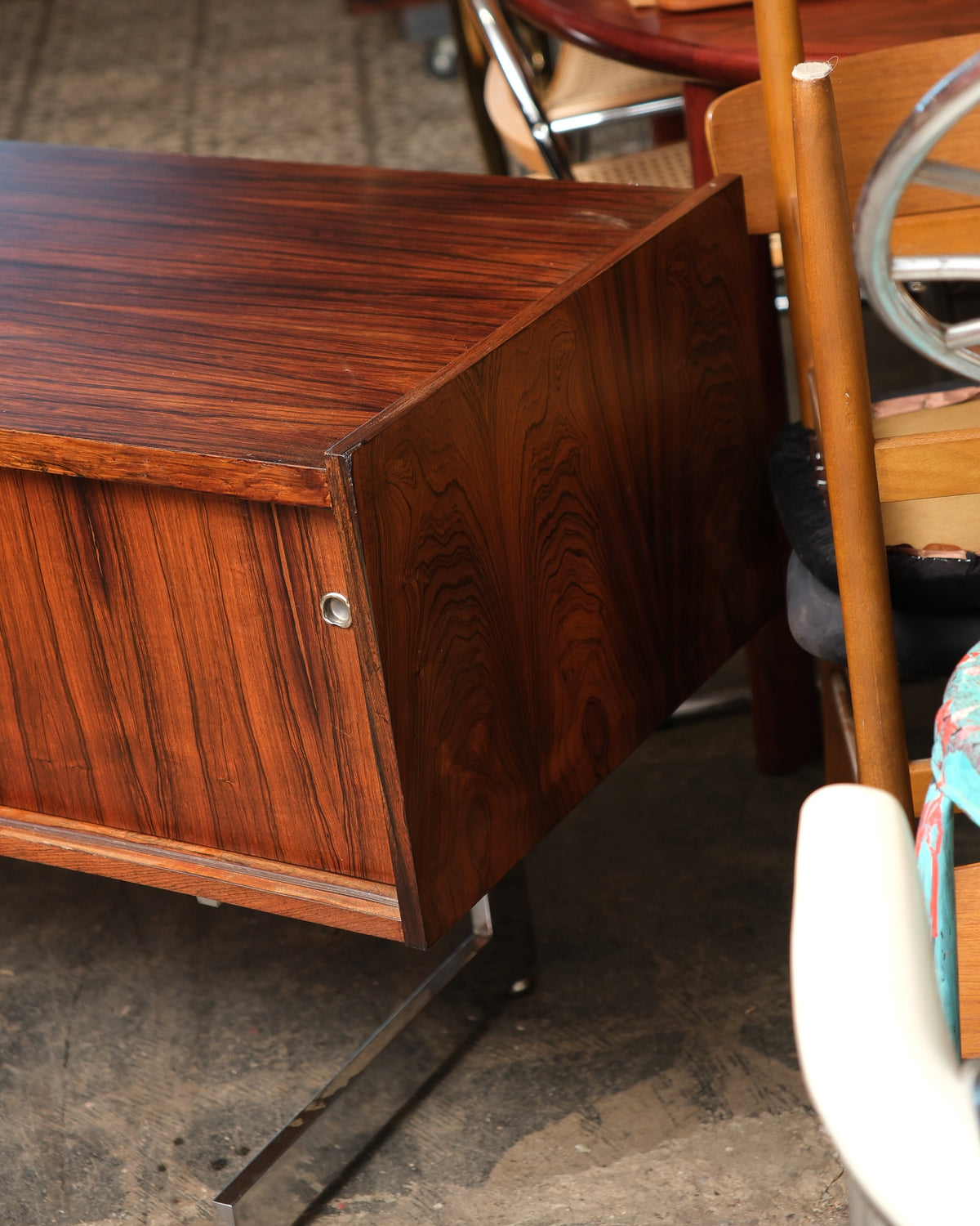 Close-up of the credenza's corner and chrome door pull, showing grain and joinery detail