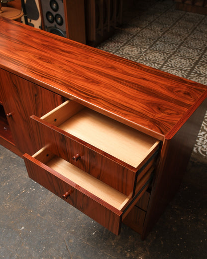 Angled view of the rosewood sideboard's top and open drawers showing rich grain and interior construction.