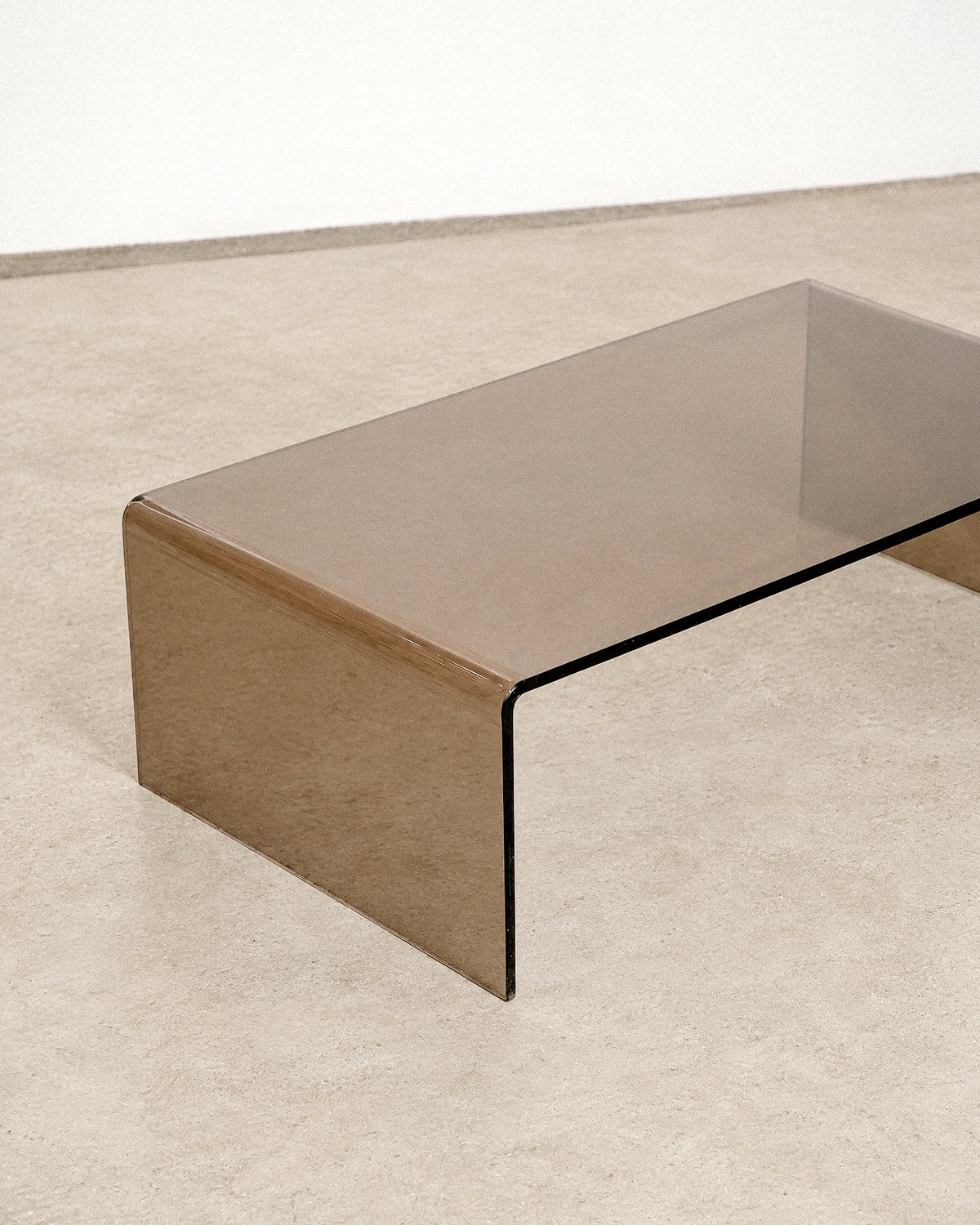 Side angle of the coffee table showing the waterfall silhouette against a plain wall.