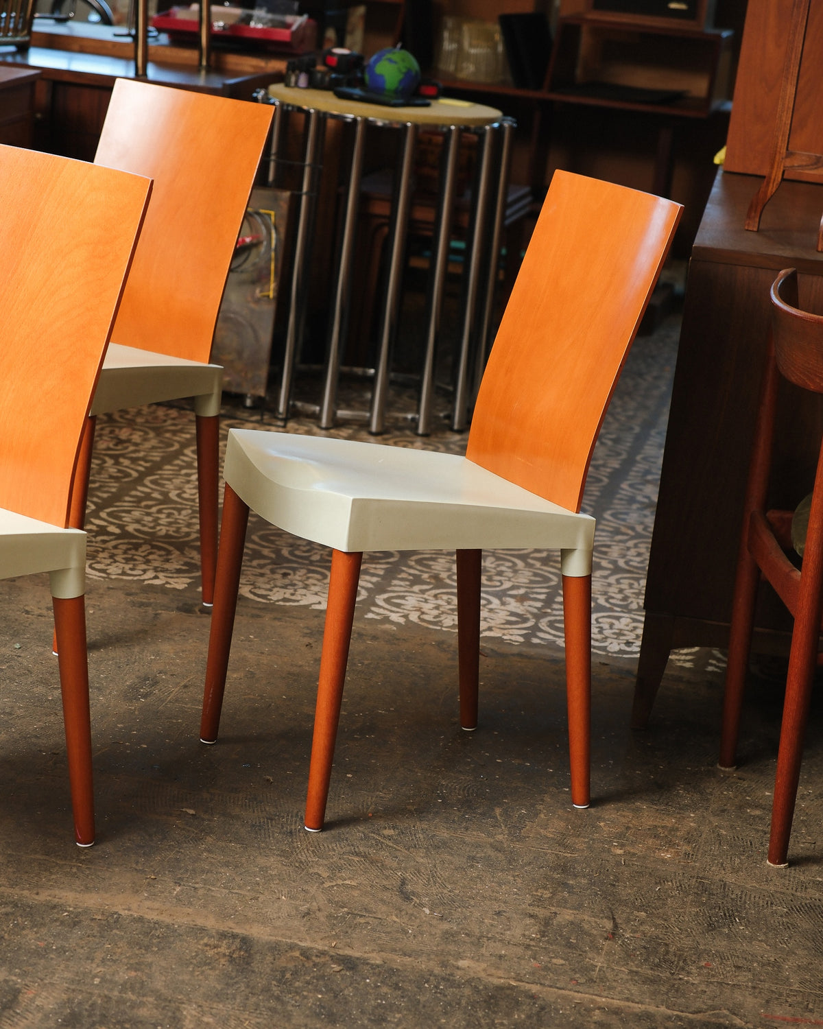 Angled view of two Miss Trip chairs showing the curved seat profile and tapered wooden legs.