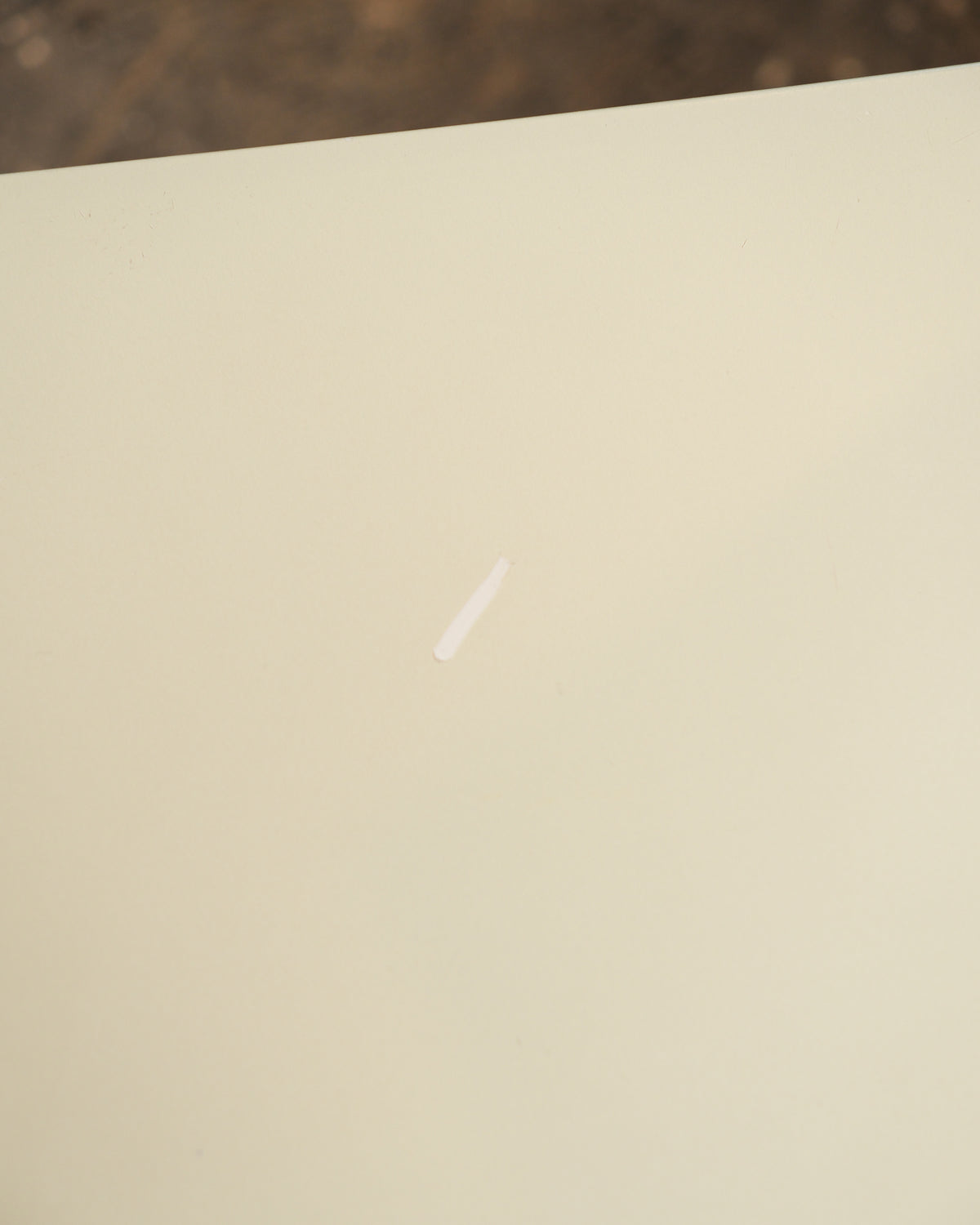 Close-up of the cream seat surface showing a small visible scratch.