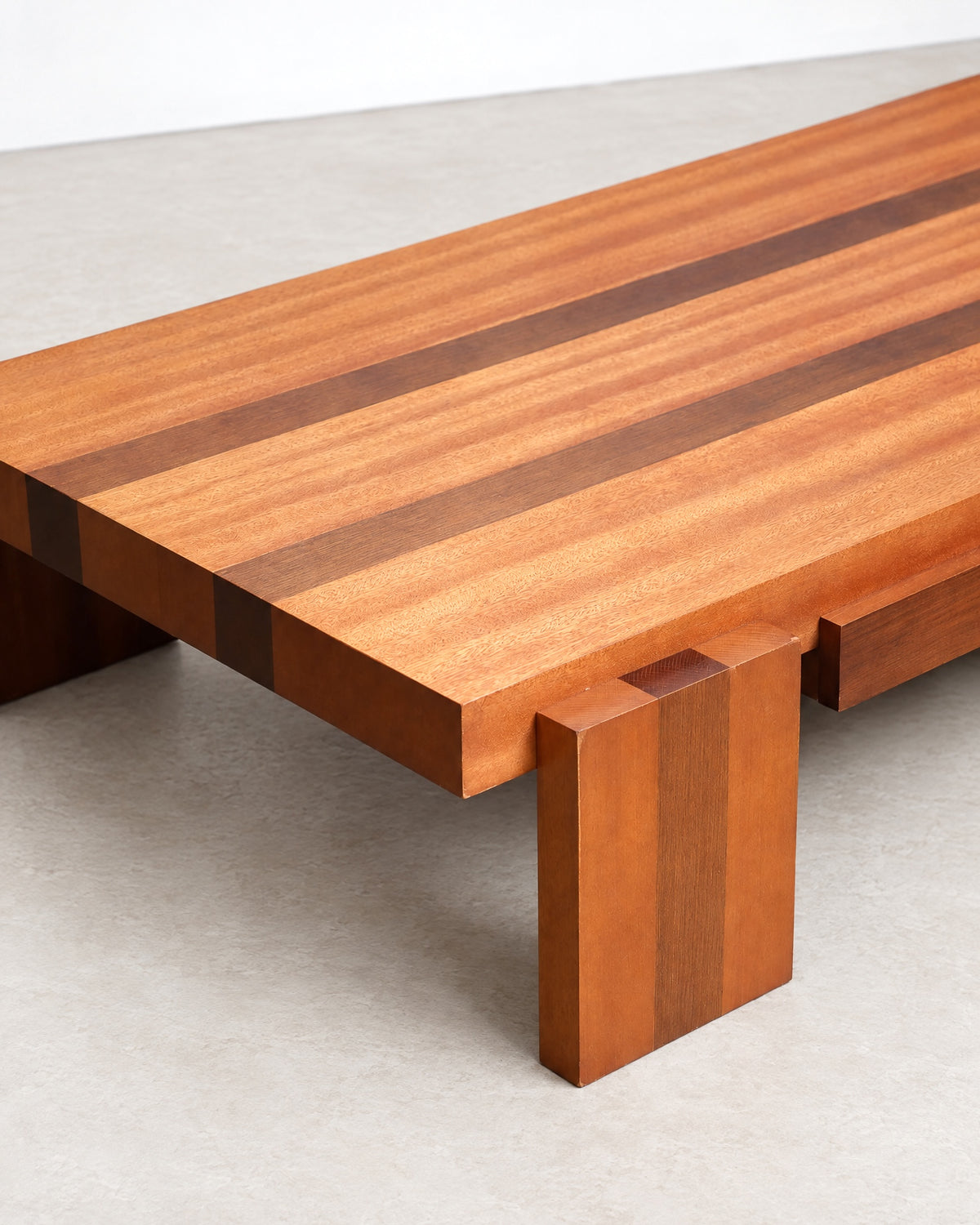 Close-up of the tabletop grain and corner joinery showing contrasting wood stripes.