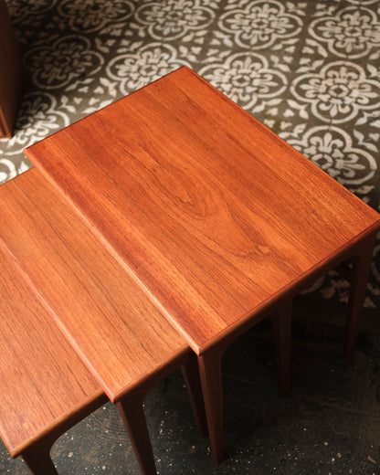 Angled overhead view of the two smaller tables nested together on a patterned floor