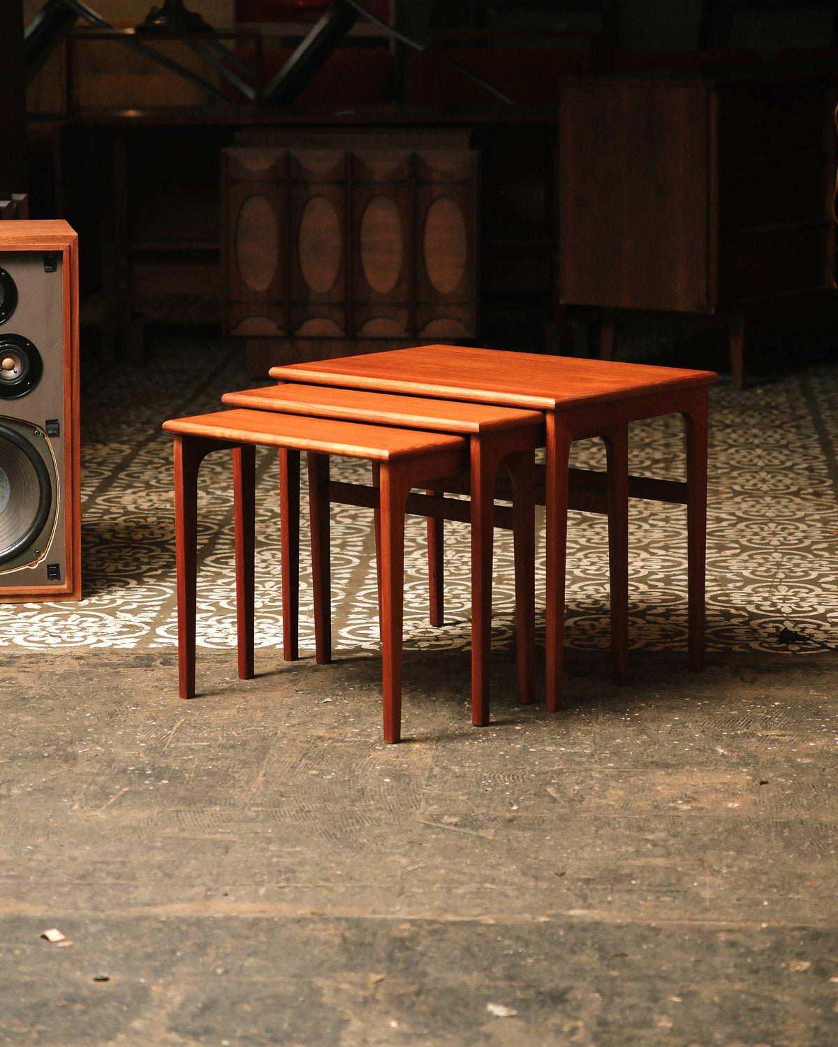 Full set of three nesting tables arranged together in a showroom setting