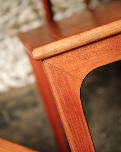 Close-up detail of the sculpted leg and corner joinery on one of the tables