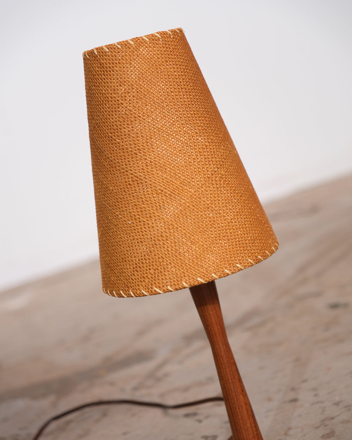 Close-up of the woven cone shade and teak stem of the vintage table lamp, shown at an angle.
