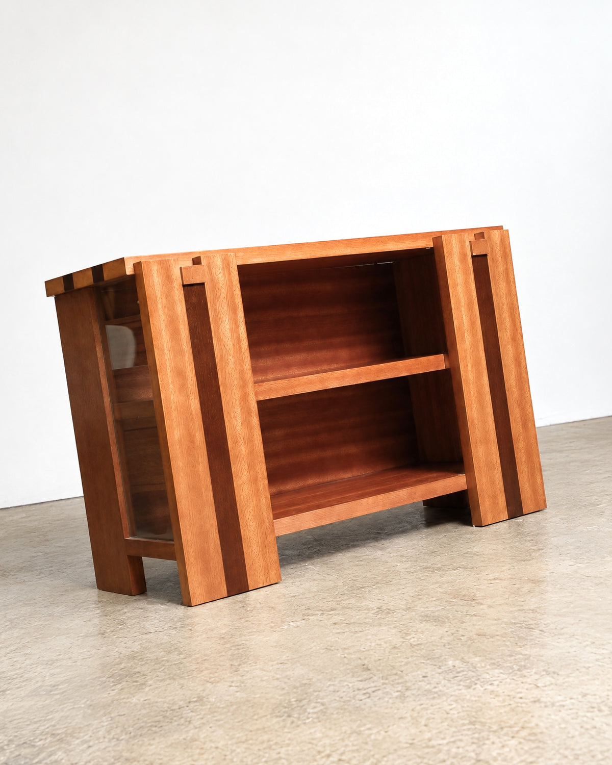 Angled view of the cabinet showing both the glass door side and open shelf side.