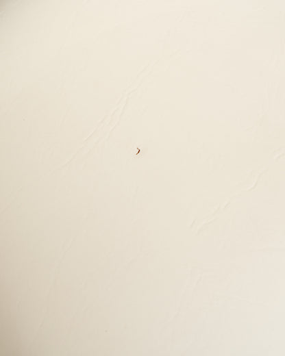 Close-up detail of vintage leatherette upholstery texture on an Arthur Umanoff dining chair.