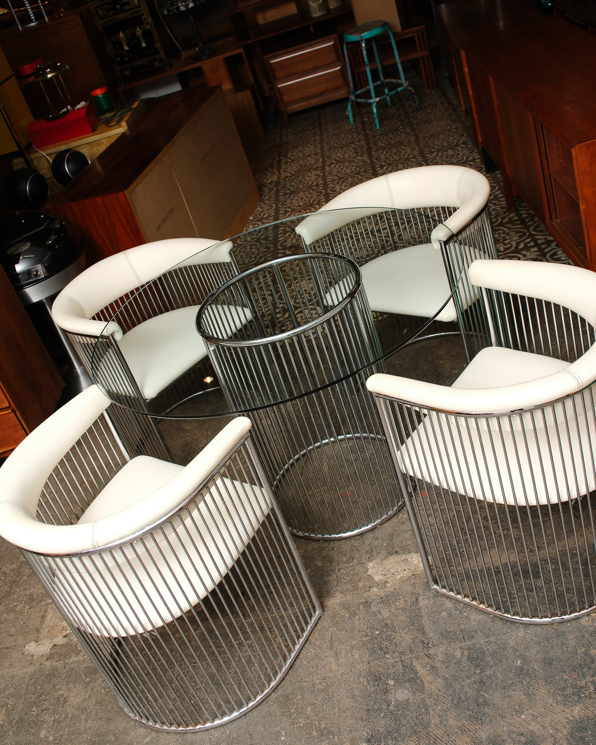Overhead angle of the complete dining set with four chairs arranged around the round glass table.