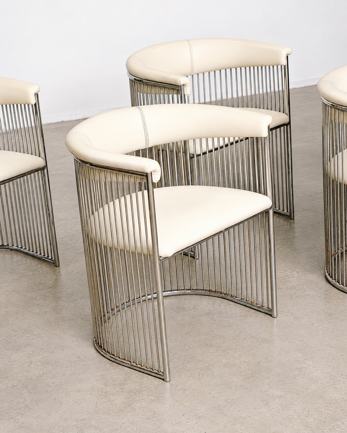 Close-up of the chrome vertical rods forming the chair and table bases.