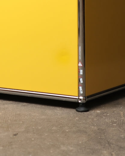 Front view of the USM Haller side table in golden yellow.
