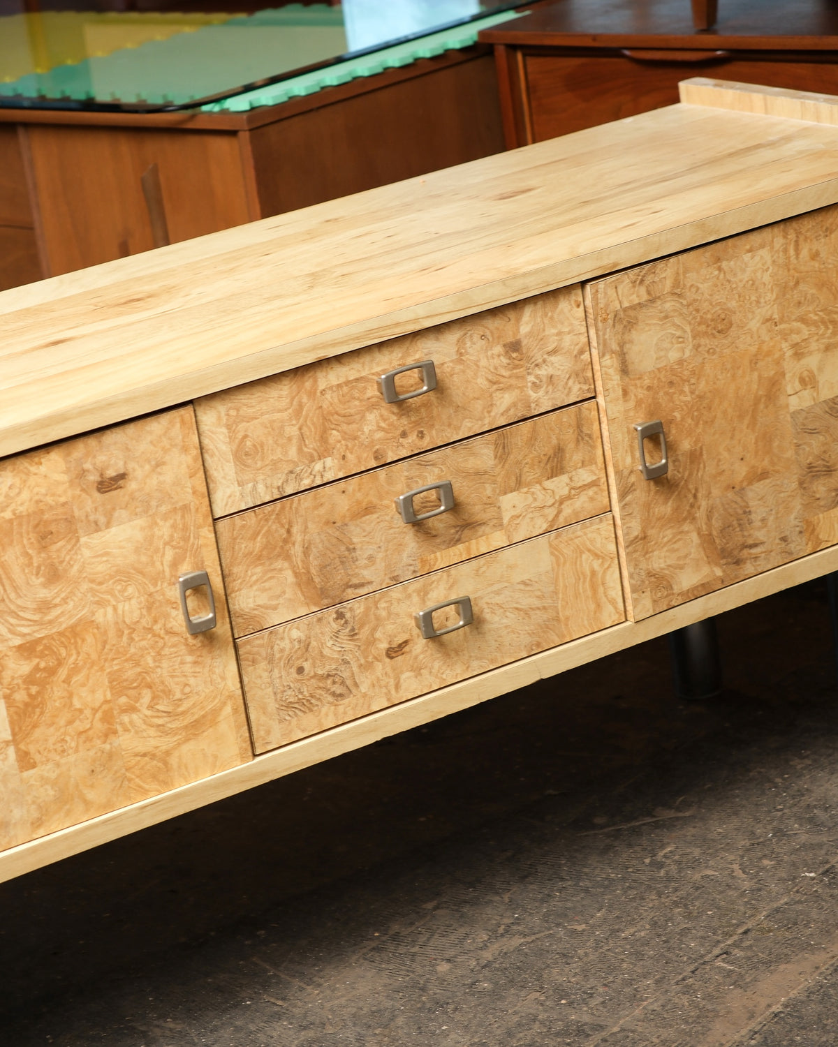 Overhead angle of the sideboard top showing the solid wood surface and burl drawer fronts.