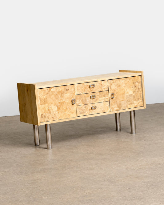 Detail of the sculpted metal drawer pull against the burl wood surface.