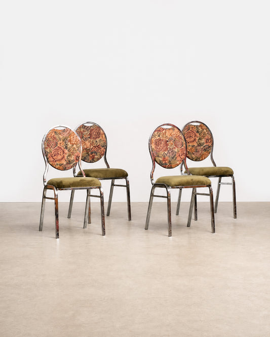 Four chairs with patterned backrests and green cushions on a light gray floor.