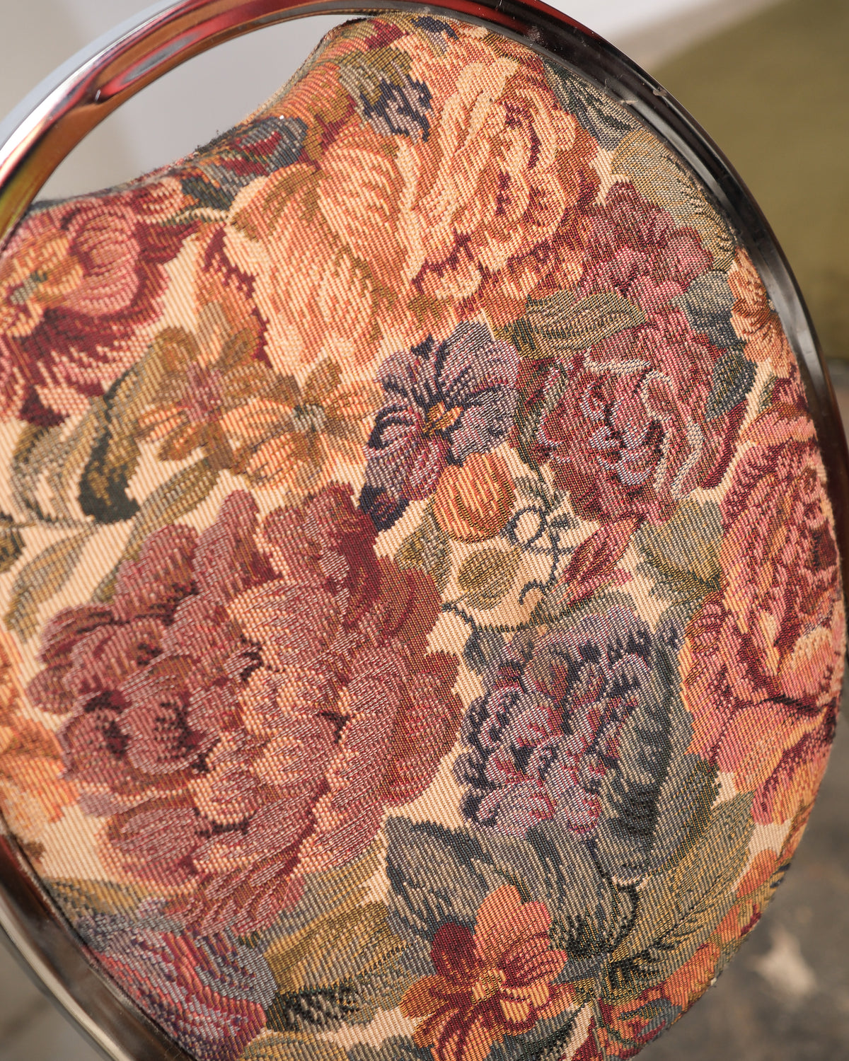 Close-up of a floral-patterned fabric with rich colors on a circular object.
