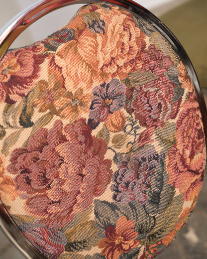 Close-up of a floral-patterned fabric with rich colors on a circular object.