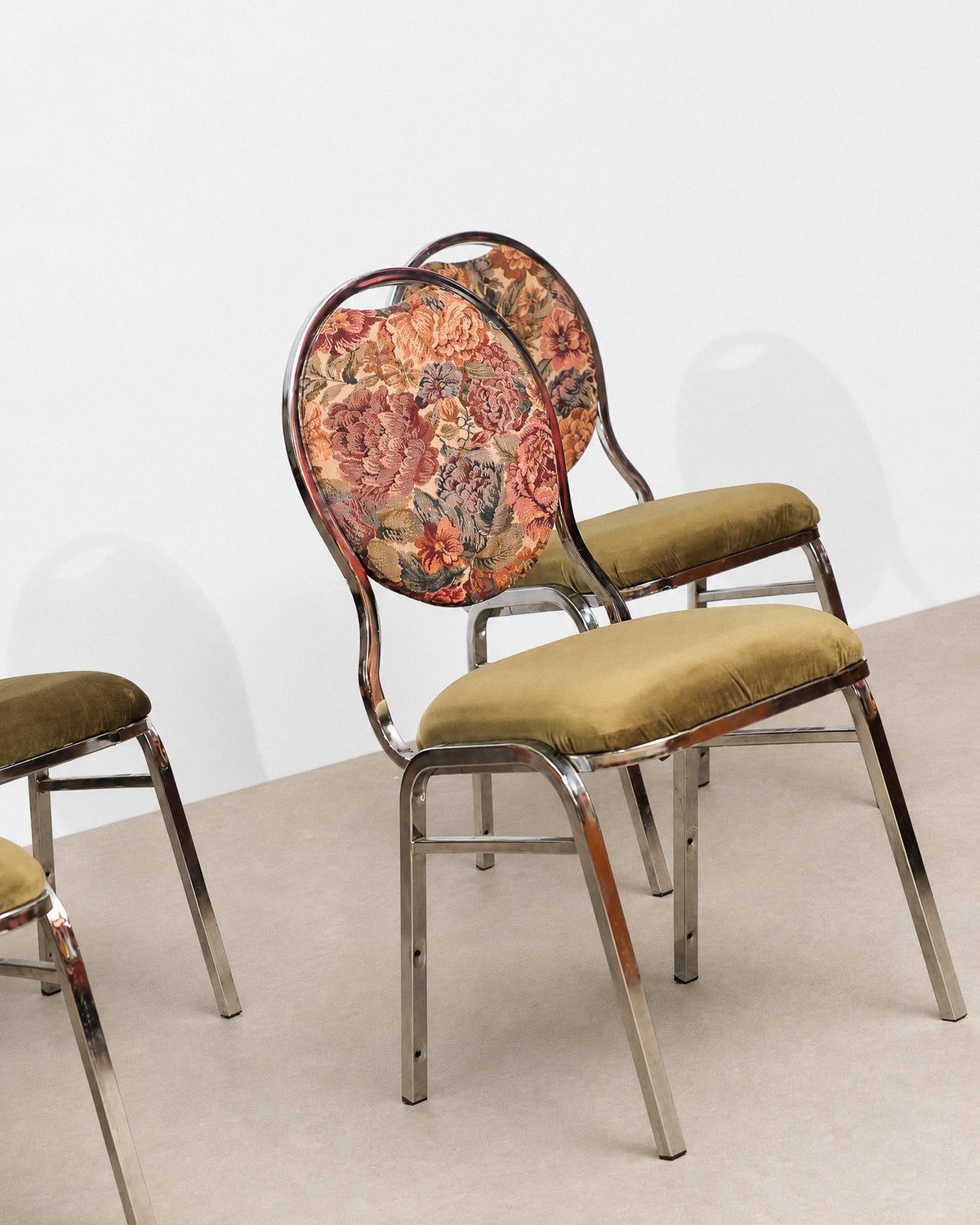 Floral-patterned chair with chrome frame on a plain background