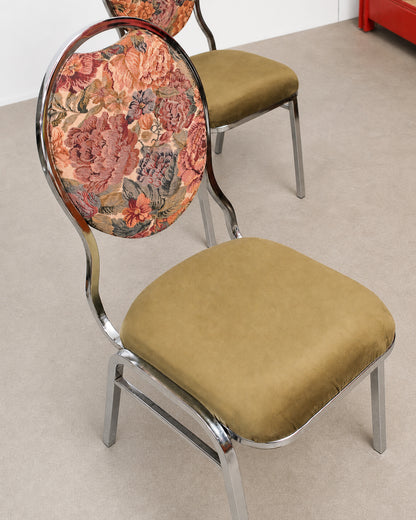 Chair with floral backrest and brown seat on a plain floor.