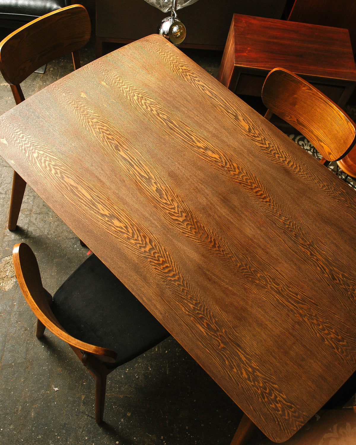Overhead view of the table showing the refinished tabletop grain with two chairs at the corners.
