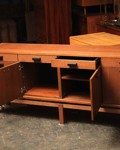 Interior view of the oak sideboard with one door open, showing the shelf, small drawer, and cabinet framing.
