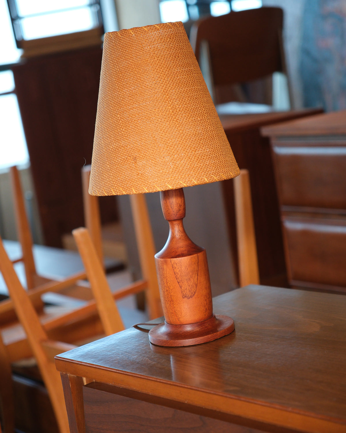 Side angle of the walnut lamp base highlighting its sculptural shape.
