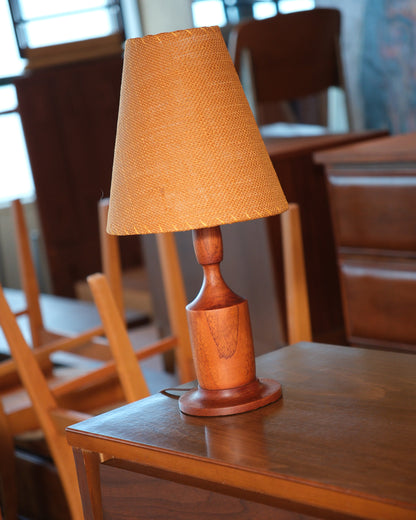 Side angle of the walnut lamp base highlighting its sculptural shape.