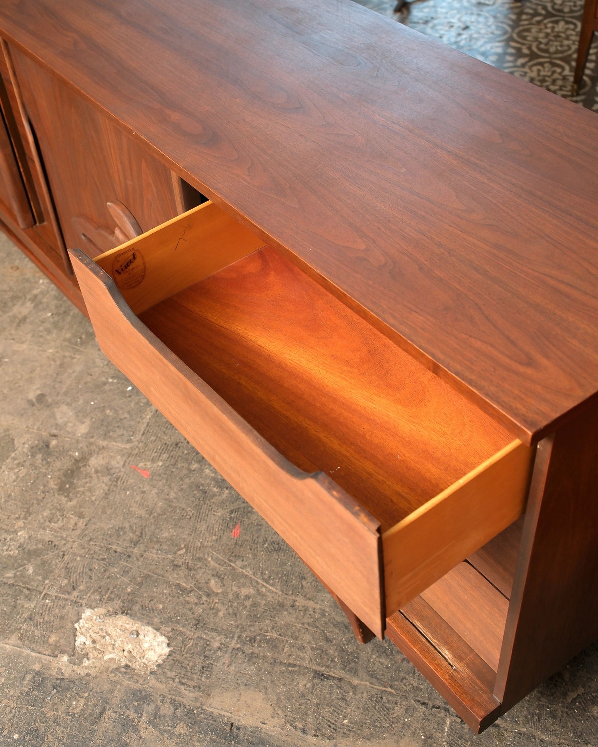 Open drawer of the walnut sideboard showing dovetail joinery and the Viscol maker's label inside