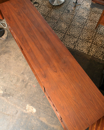 Overhead view of the walnut top showing grain and drawer lines along the case