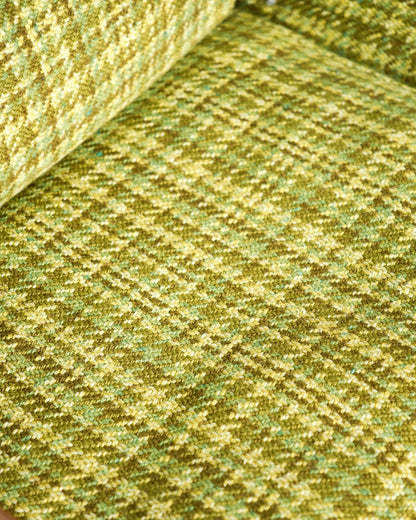 Detail of the green plaid tweed upholstery texture on the sofa cushions.