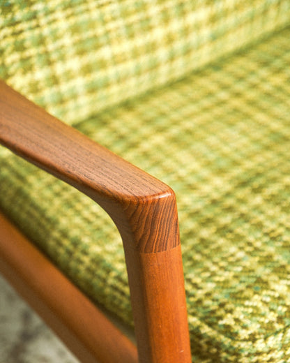 Close-up of the sculpted teak armrest showing joinery and wood grain.