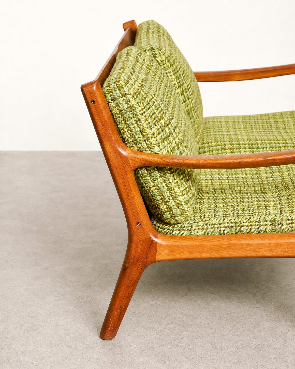Close-up of a teak armrest and its rounded joinery detail.